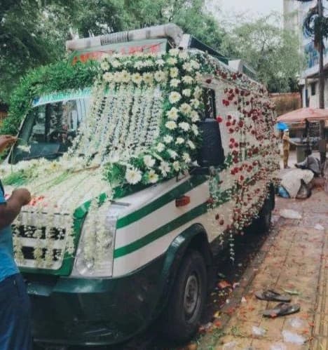 Decorated mortuary van with floral garlands, ready for the family